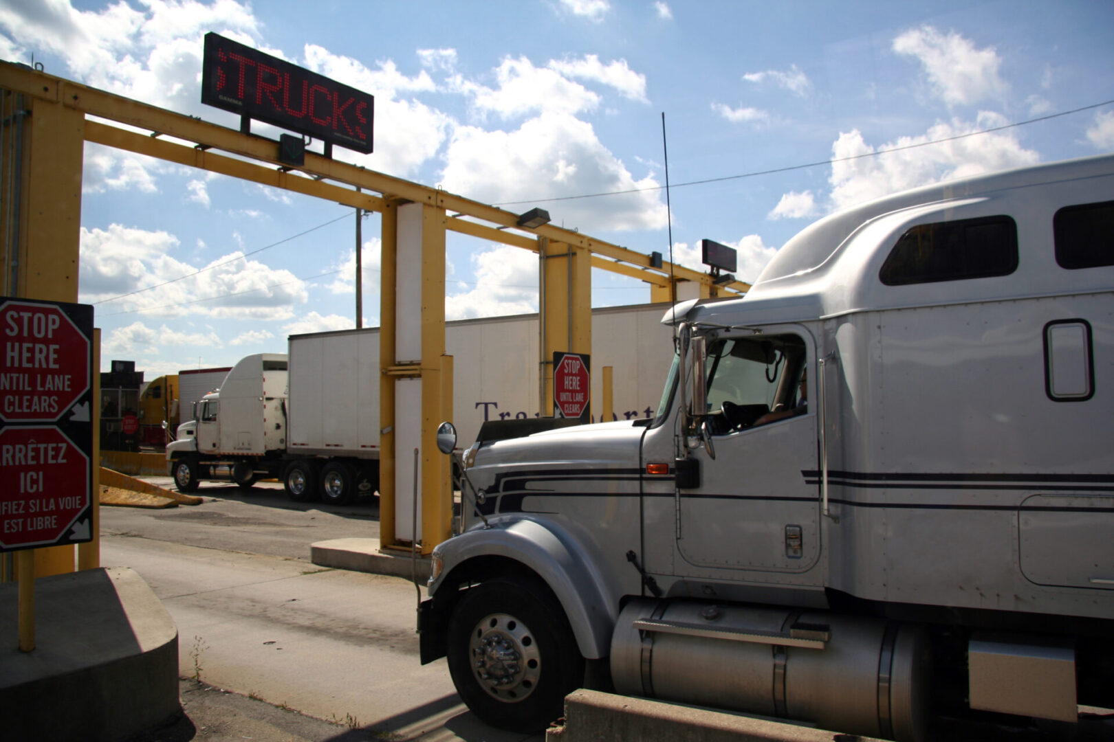 A semi truck is parked at the side of a road.