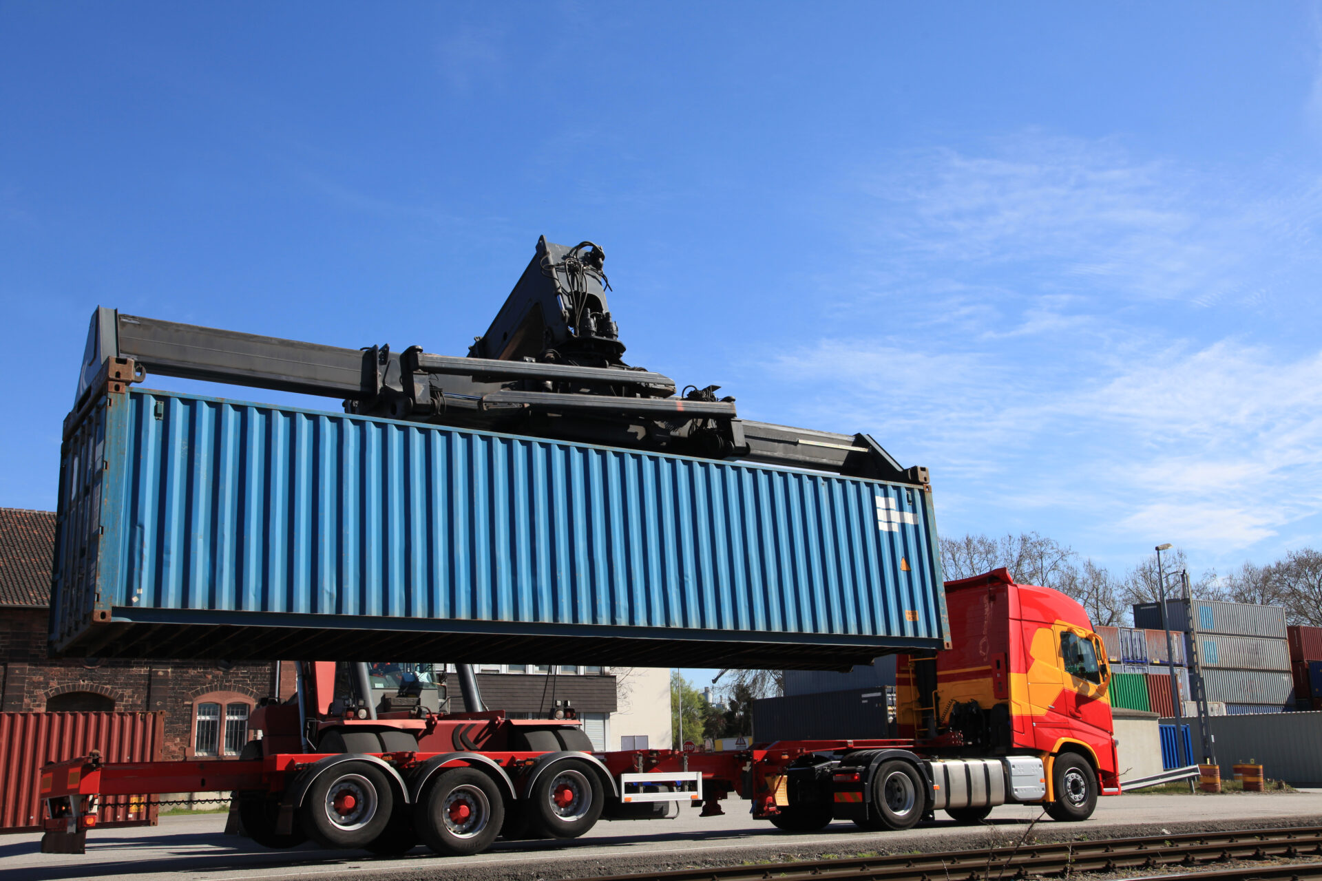 A large truck is pulling a trailer with a crane on it.